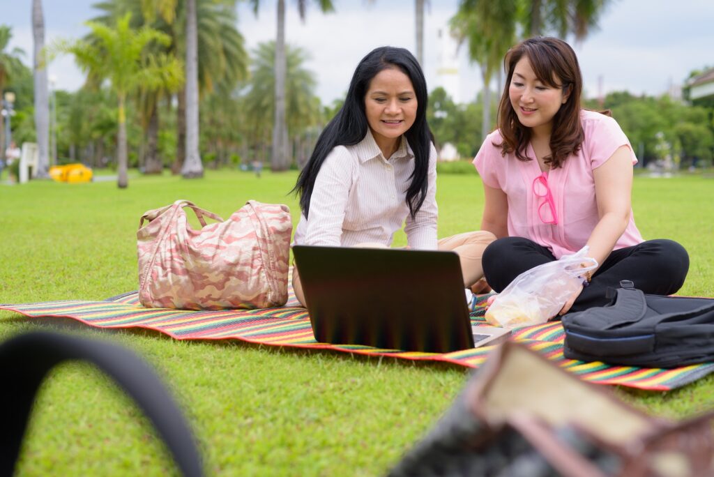 Two mature Asian women together relaxing at the park talking about Singapore Urogynae.